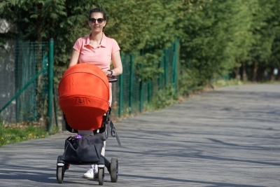 Frau schiebt Kinderwagen