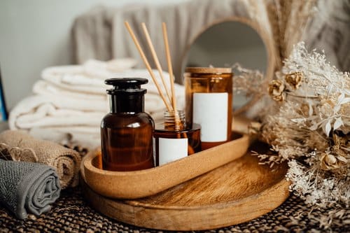 Entspannungs-Paket selbst zusammenstellen: Holztablett mit Ölfläschchen, Duftstäbchen, Handtüchern und Trockenblumen