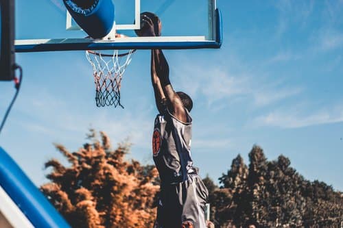 Basketball: Spieler beim Dunk an einem Korb unter freiem Himmel