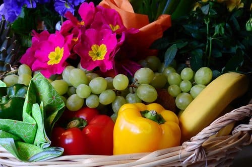 Vegetarischer Geschenkkorb selbst zusammenstellen: Weidenkorb mit Trauben, Paprika, Banane und Blumen