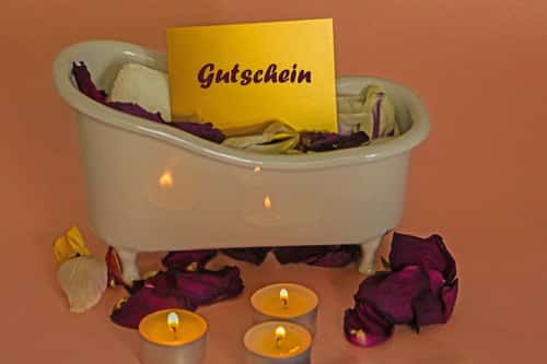 Wellness-Gutschein verschenken: Mini-Badewanne mit Gutscheinkarte, Rosenblättern und Teelichtern